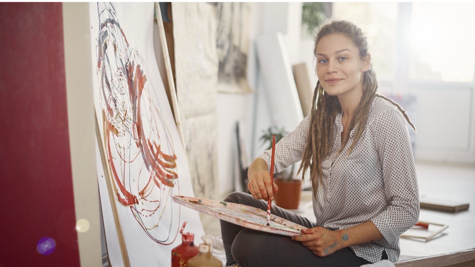 Blick in ein Atelier mit Leinwänden und Farben